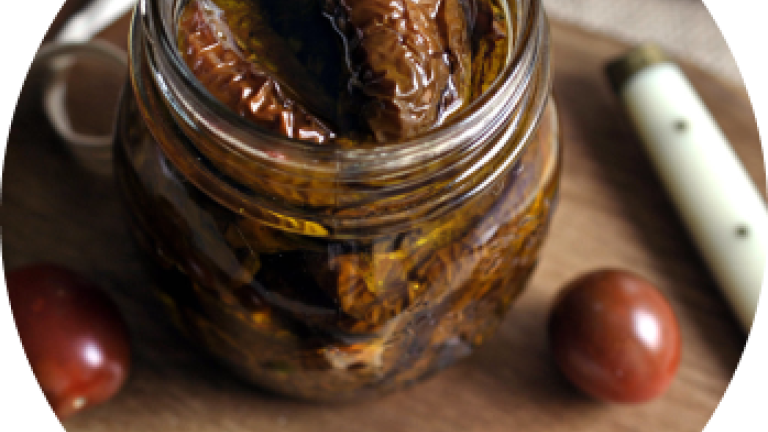 Tarro de vidrio con higos en conserva sobre tabla de madera, con uvas alrededor